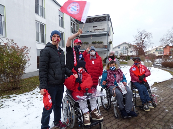 Bewohner*innen der Priener Wohnanlage mit FC Bayern Fanartikeln